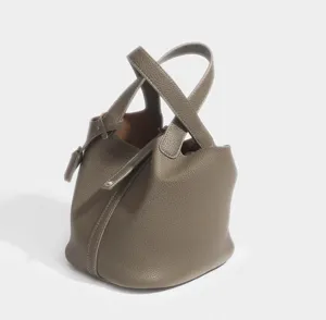 Detail view of the taupe PU leather bucket handbag showing double top handles and lock strap.