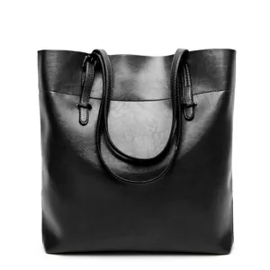 Black leather tote bag detail view, showcasing premium texture, sturdy handles, and spacious design.