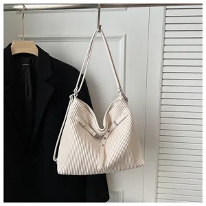 Pleated design leather shoulder bag detail, elegant white tote bag with adjustable strap accent.