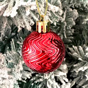 Rote strukturierte Weihnachtskugel Nahaufnahme, glänzende Kunststoff Baumhängedeko Detail.