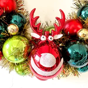 Weihnachtskranz Dekoration mit rotem Rentier und bunten glänzenden Kugeln für Feiertage