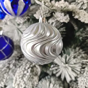 Detailaufnahme einer silbernen galvanisierten Weihnachtskugel mit funkelnden Glitzerwirbeln.
