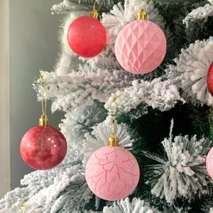 Nahaufnahmen von Vintage-Crackle und glänzenden rosa roten Weihnachtskugeln im Schnee.