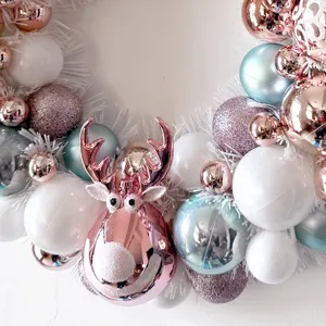 Weihnachtskranz Dekoration mit rosafarbenem Rentier Ornament und bunten Christbaumkugeln.