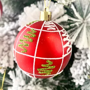 Rote Christbaumkugel Nahaufnahme Detail, glitzernde Zickzack-Muster auf verschneitem Zweig.
