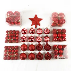 Detailansicht von roten Christbaumkugeln mit Stern Baumspitze und Geschenkboxen.