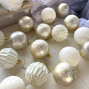 Nahaufnahme von Vintage Weihnachtsbaum Kugeln mit Crackle- und Schneeflockenmuster in Gold-Weiß.
