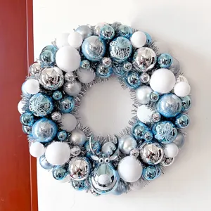 Detailansicht des blau-silbernen Weihnachtskranzes mit glänzenden Kugeln und Rentiermotiv.
