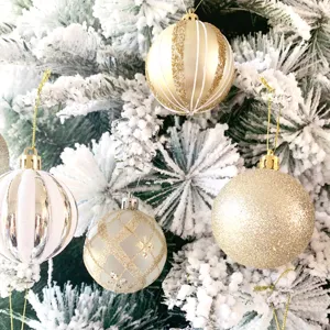 Nahaufnahme von hängenden Christbaumkugeln mit goldenen glänzenden Akzenten und Glitzer.