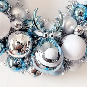 Weihnachtskranz Dekoration mit blauen silbernen Kugeln und süßem Rentier für Feiertage.