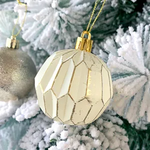 Nahaufnahme einer vintage cremefarbenen Weihnachtskugel mit dekorativem antiken Riss-Effekt.