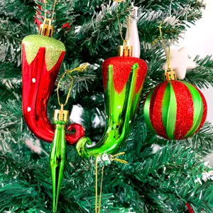 Detaillierte Nahaufnahme von Weihnachtsbaum-Hängeornamenten, rote und grüne Glitzer-Chilis.