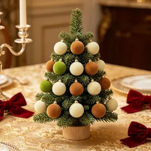 Detailansicht des kleinen beflockten Weihnachtsbaums mit bunten Samtkugeln und dem Holzfuss.