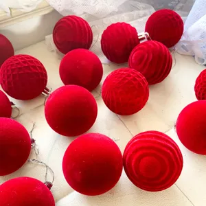 Rote beflockte Christbaumkugeln, Detailaufnahme von strukturiertem festlichen Hängeschmuck.