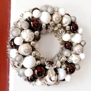 Detailansicht der eleganten Weihnachtskranz Dekoration mit weißen silbernen und braunen Kugeln.