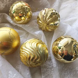 Detailansicht goldener Weihnachtskugeln, galvanisierte Kunststoffornamente mit glitzerndem Dekor.