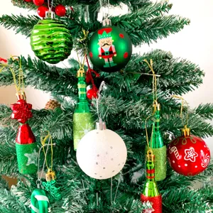 Nahaufnahme Detail von bunten Weihnachtsbaum Anhängern, festlichen Christbaumkugeln und Flaschen.