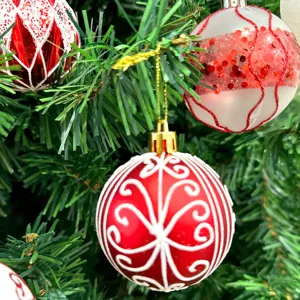 Nahaufnahme von rot-weißen, wunderschön bemalten Christbaumkugeln mit filigranen Mustern.