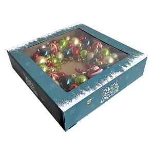 Detailansicht des Weihnachtskranzes im Geschenkkarton mit bunten Kugeln und festlichem Design.
