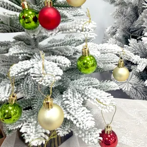 Detailaufnahme des beflockten Mini-Weihnachtsbaums mit glänzenden bunten Weihnachtskugeln.