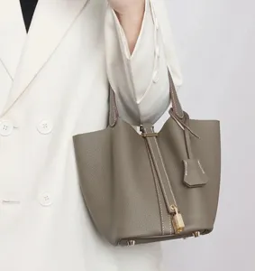 Elegant taupe pu leather bucket bag with lock closure, chic minimalist design for women.