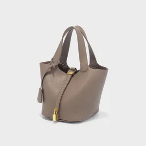 Detailed view of the taupe PU leather bucket handbag with a gold padlock and dual top handles.
