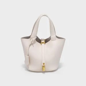 Minimalist PU leather bucket handbag detail shot, elegant cream white tote bag with lock.
