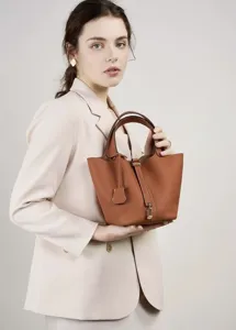 Detailed view of the brown PU leather bucket handbag showcasing its classic handle and metal lock.