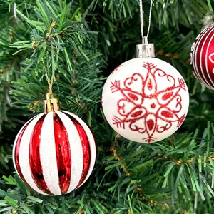 Nahaufnahme Detailansicht von rot weiß bemaltem Christbaumkugel Weihnachtsschmuck am Tannenbaum.