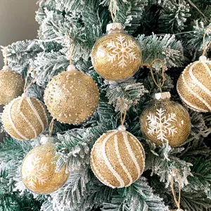 Goldene Glitzer Weihnachtskugeln Set mit weißen Schneeflocken und Perlen am Baum hängen.