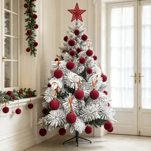 Beflockter Weihnachtsbaum mit dunkelroten Samtkugeln und Sternspitze für die Feiertage.