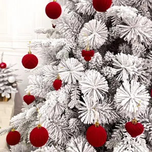 Nahaufnahme von weißem künstlichem Weihnachtsbaumast mit roten Samt Christbaumkugel Details.