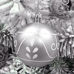 Detaillierte Ansicht einer silbernen Weihnachtskugel mit Glitzerornamenten am verschneiten Ast.
