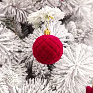 Nahaufnahme Detailaufnahme einer roten Samt gesteppten Weihnachtsbaum Kugel mit goldener Kappe.