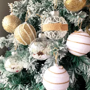 Nahaufnahme von hängenden Christbaumkugeln mit Glitzer und klaren Schneekugeln im Detail.