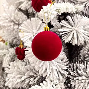 Nahaufnahme Detail der roten Samt Weihnachtskugel Dekoration am gefrosteten Tannenzweig.