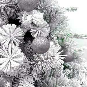 Nahaufnahme des gefrosteten Weihnachtsbaums mit silbernen Glitzer- und Hohlkugeln.