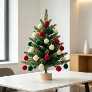 Kleiner Desktop-Weihnachtsbaum geschmückt mit beflockten Samtkugeln in Rot, Grün und Creme.