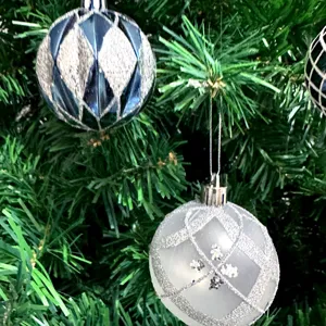 Detailaufnahme von Weihnachtsbaumschmuck, dekorativer galvanisierter bemalter Kugelanhänger.