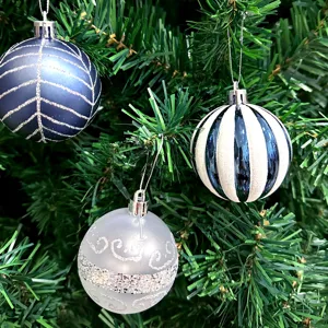 Detailaufnahme von hängenden Weihnachtskugeln mit einzigartigen Mustern am Tannenbaum.