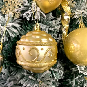 Nahaufnahme von goldenen Weihnachtsbaum-Hängeornamenten mit glänzendem Finish und Glitzer.