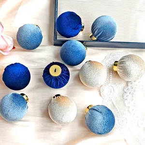 Detailansicht blauer und champagnerfarbener Samt-Weihnachtskugeln mit Goldkappen für Dekor.
