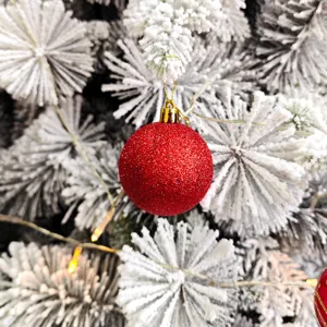 Nahaufnahme rote glitzernde Christbaumkugel Dekoration fuer festlichen Weihnachtsbaum