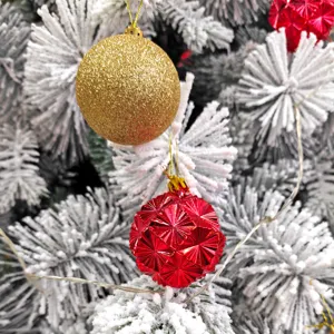 Nahaufnahme von glitzerndem Gold und facettierten roten Christbaumkugeln als Dekoration.