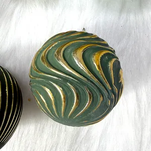 Detaillierte Nahaufnahme der gruenen und goldenen gepraegten Weihnachtskugel im Vintage-Stil.