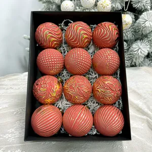 Detailansicht rot gold geprägter Christbaumkugeln dekorativ angeordnet in einer eleganten Schachtel.