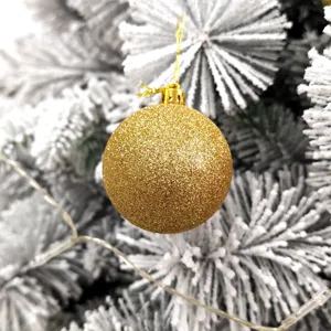 Nahaufnahme Detailansicht einer glitzernden goldenen Weihnachtskugel am Weihnachtsbaum.