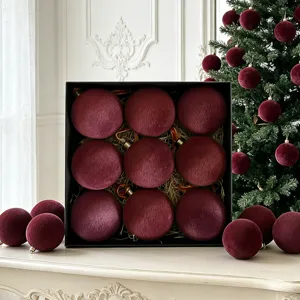 Rote Samt Weihnachtskugeln im edlen schwarzen Geschenkkarton, Detailaufnahme der Festtagsdeko.