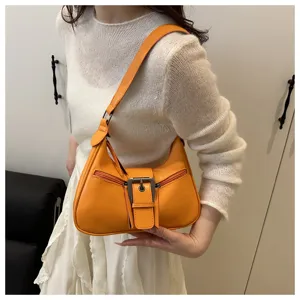 Close-up detail shot of the vibrant orange hobo underarm bag showing metal buckle.