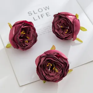 Artificial rose heads detail shot, burgundy faux flowers for DIY crafts and wedding decor.